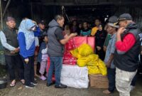 Kepala Dinas Sosial Provinsi Lampung, Aswarodi menyalurkan bantuan kepada warga yang terdampak banjir | Foto: Ist.