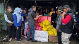 Kepala Dinas Sosial Provinsi Lampung, Aswarodi menyalurkan bantuan kepada warga yang terdampak banjir | Foto: Ist.